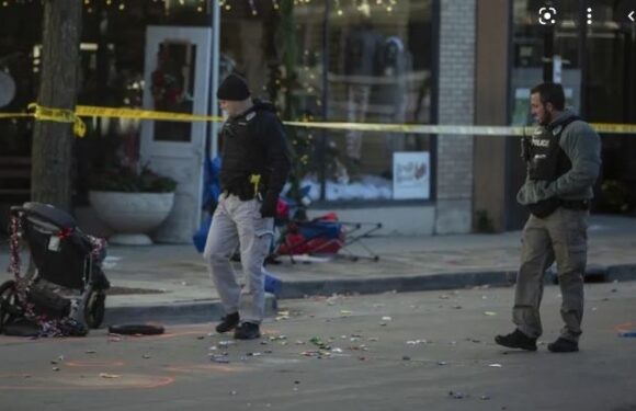 Two police officers investigating a damaged stroller on a city street, with debris and caution tape in the background.