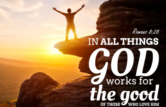 A person standing on a rock formation with arms raised at sunset, with a quote from Romans 8:28 about God's work for those who love Him.