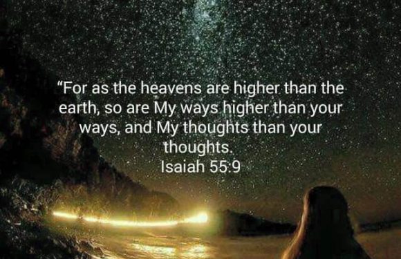 A person sits on a rocky beach at night, gazing at a starry sky with the Milky Way, with a quote from Isaiah 55:9 about God's ways and thoughts being higher.