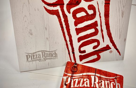 A white wooden textured gift bag with a large red logo, and a matching red gift card with the Pizza Ranch logo, placed on a white surface.