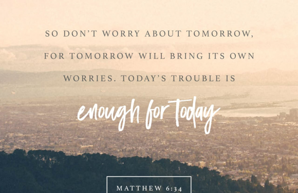 Inspirational quote over a scenic landscape: "Don't worry about tomorrow, for tomorrow will bring its own worries. Today's trouble is enough for today," from Matthew 6:34.