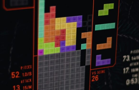 A screenshot of a Tetris game in progress, showing different colored blocks arranged on the grid, with player names, scores, and game stats displayed.