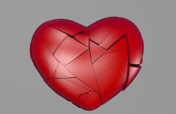 A broken red 3D heart with visible cracks and missing pieces on a gray background.