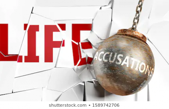 A wrecking ball labeled "ACCUSATION" crashes through a wall with the word "LIFE," causing debris to fly.