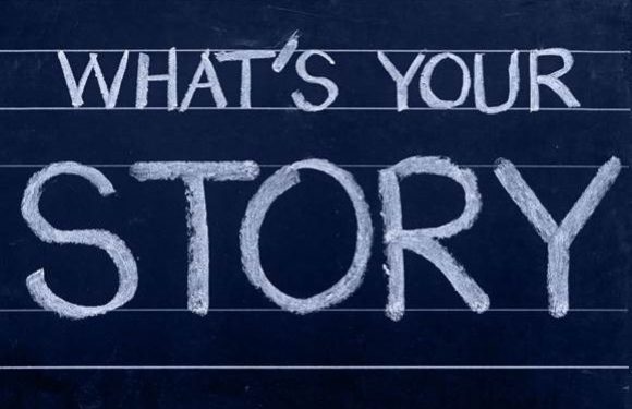 "What's your story" written in chalk on a dark blue chalkboard with horizontal lines.