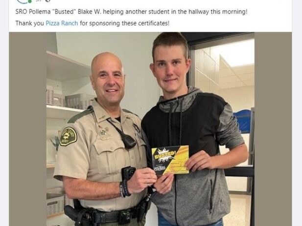 Blake receives a Pizza Ranch Certificate from Police Officer Pollema