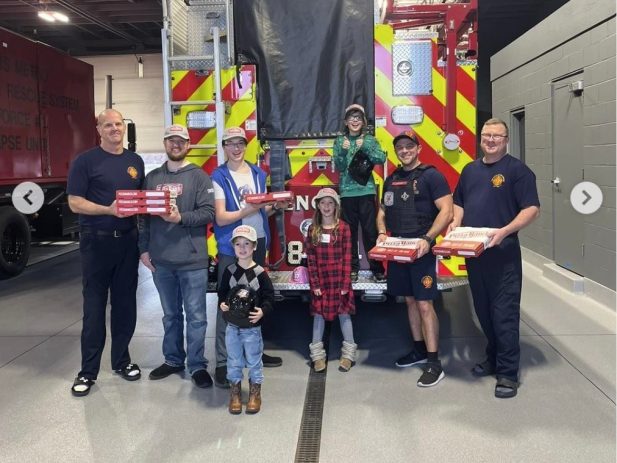 Pizza Ranch staff and fireman in front of fire truck.