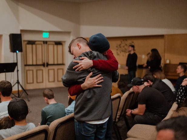 Friend giving another friend a hug as church