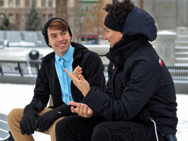 Two guys having a conversation on a park bench