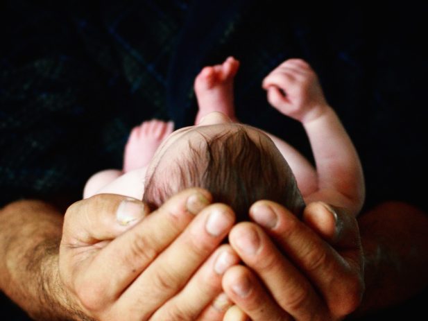 Man holding a newborn baby in his hands