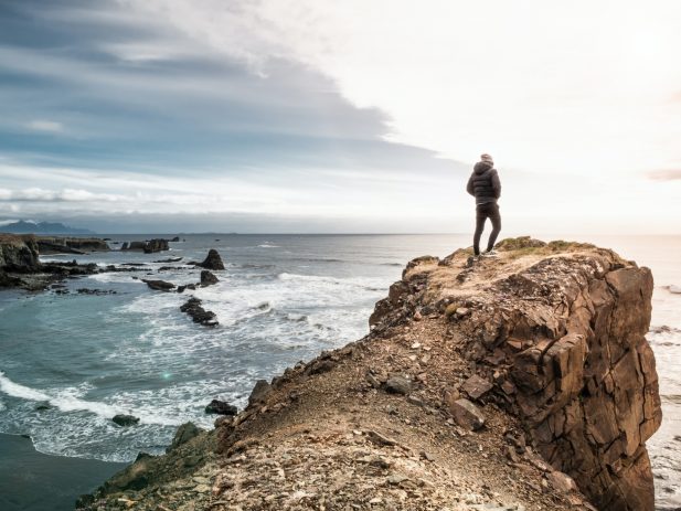 Man on a cliff overlooking the ocean