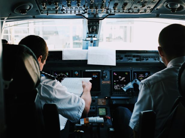 pilot & co-pilot assessing charts in a cockpit