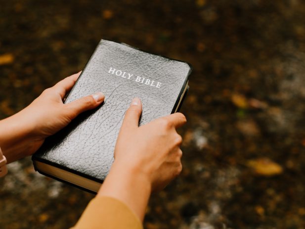 Hands holding Bible out