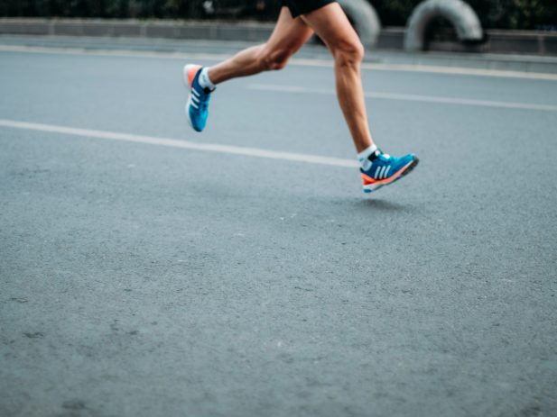 runner running on the road in blue shoes