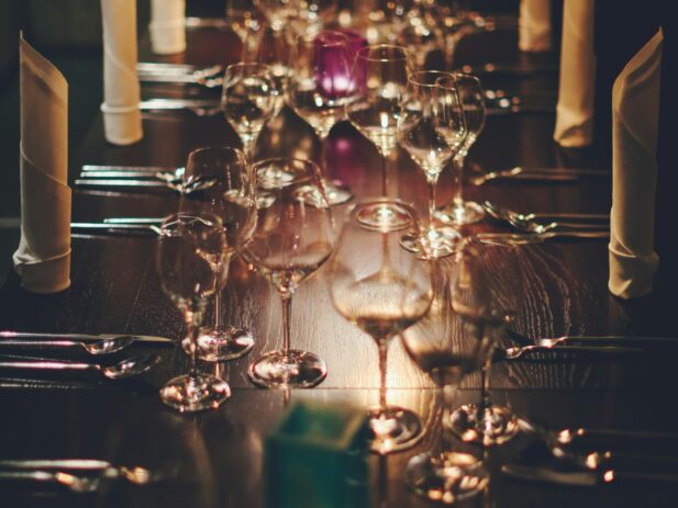 Dinner table set with empty wine glasses.
