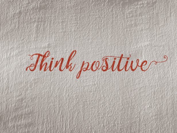 white canvas with the words "think positive" in calligraphy on it