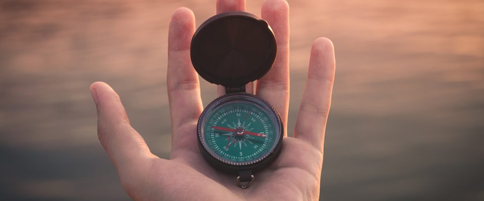 Person holding black compass.