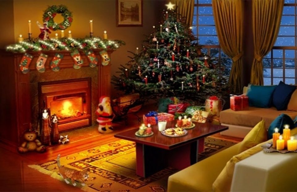 A cozy living room decorated for Christmas, featuring a lit fireplace with stockings, a decorated tree with presents, and candles on tables.