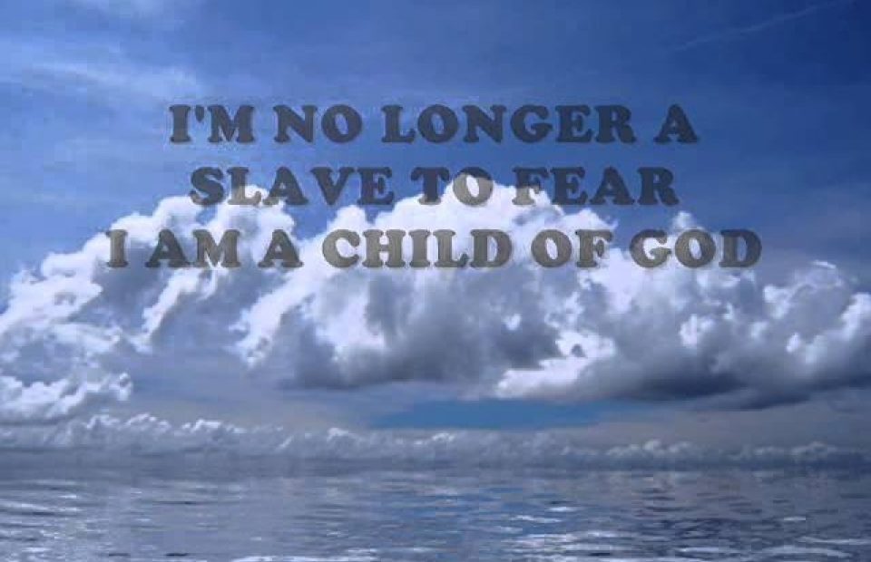 Cloudy sky over calm water with the text "I'm no longer a slave to fear. I am a child of God" in bold font.