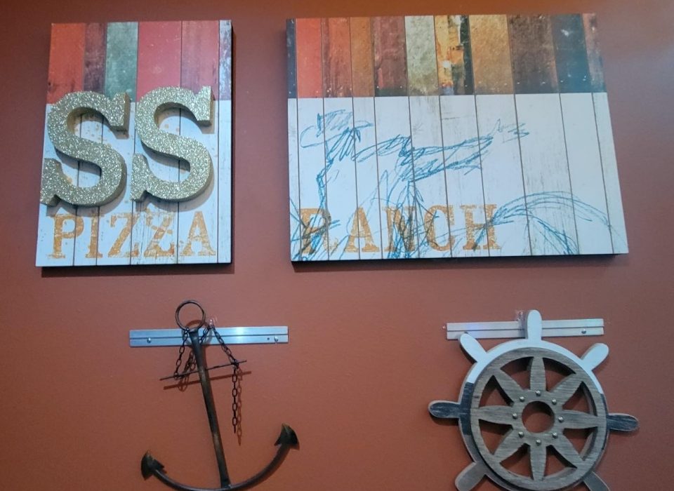 Wall decor: "SS Pizza Ranch," anchor, and a ship's wheel