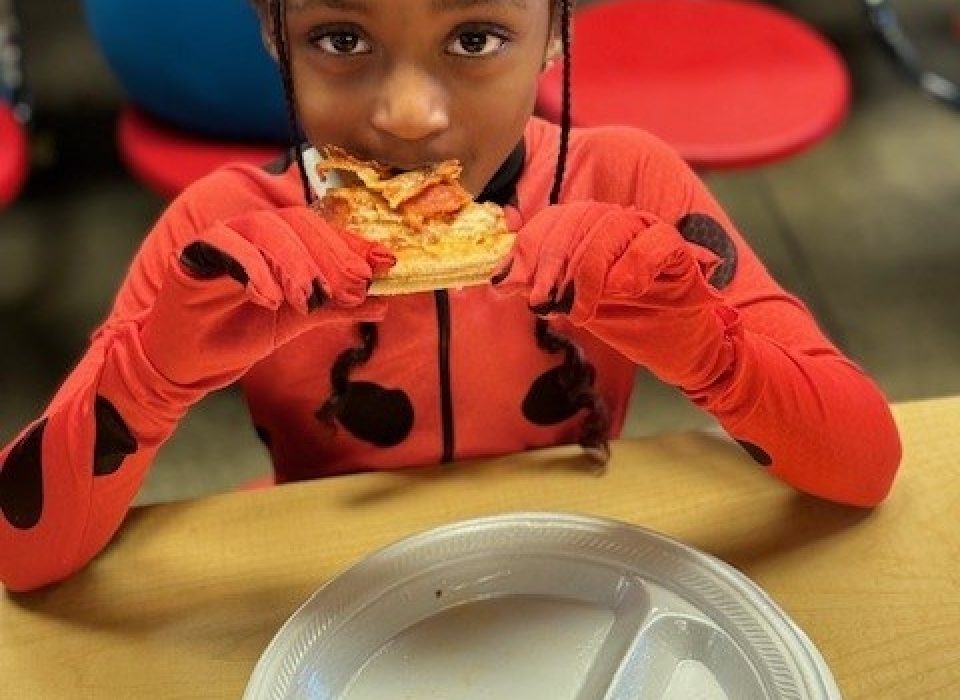 Kids enjoying pizza.