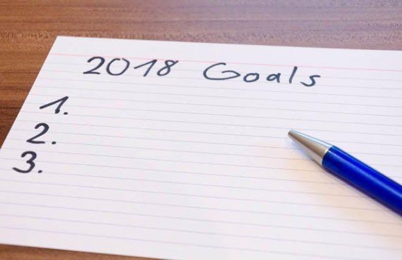 A handwritten list titled "2018 Goals" on lined paper with three numbered lines and a blue pen resting on the right side.