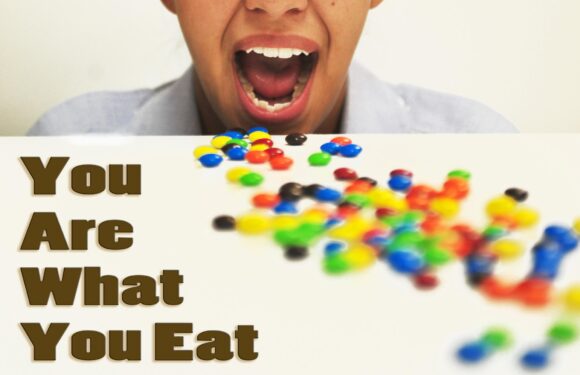 A person with open mouth surrounded by colorful candies on a white surface, with the text "You Are What You Eat" in bold brown letters.