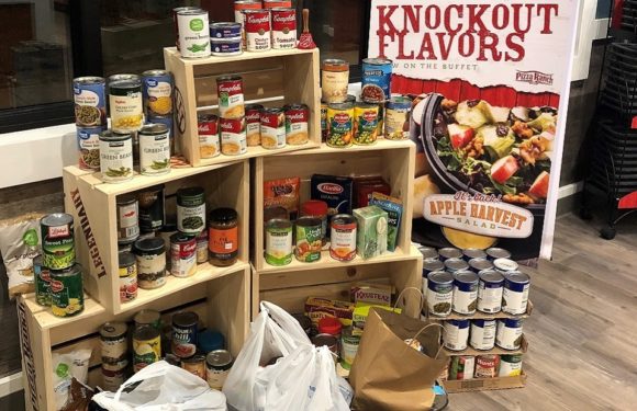 Shelves with canned goods and packaged foods in a restaurant, with a promotional poster for a salad on the right side.