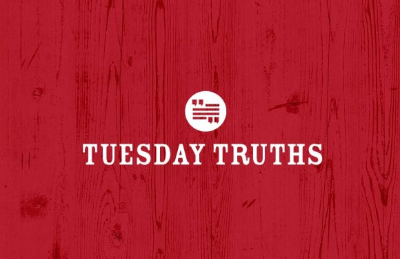 Red wooden background with white text that says "Tuesday Truths" and a circular logo above the text.