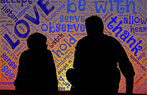 Silhouettes of two people, possibly a parent and child, sitting and talking against a colorful word cloud background with themes of love, trust, and respect.