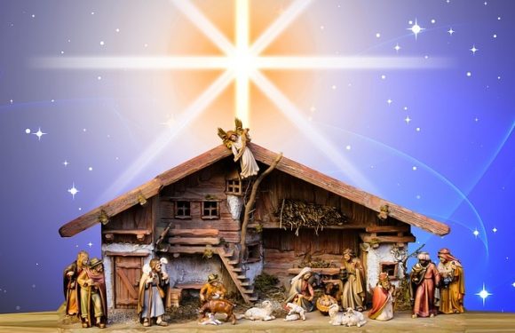A nativity scene with figurines of Mary, Joseph, baby Jesus, shepherds, Wise Men, animals, and an angel, set against a starry night sky with a bright star above.