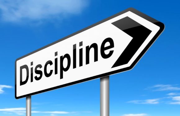 A road sign with the word "Discipline" and an arrow pointing to the right, set against a bright blue sky with a few clouds.