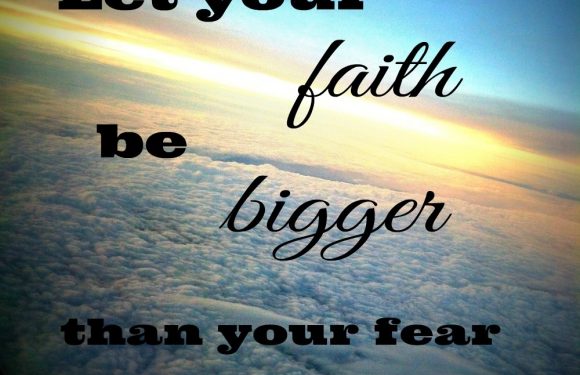 A view from an airplane window showing clouds and a colorful sky, with text: "Let your faith be bigger than your fear."