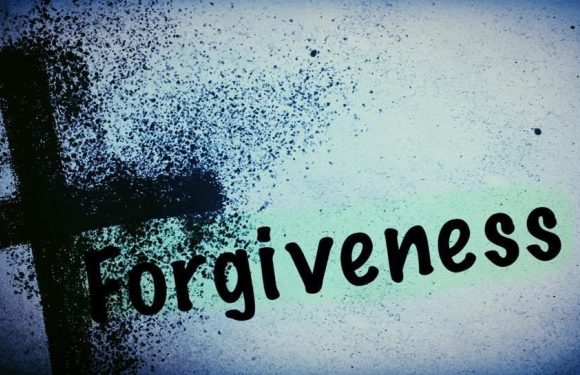 A painted black cross with the word "Forgiveness" written in black on a light background with a spray-painted effect.