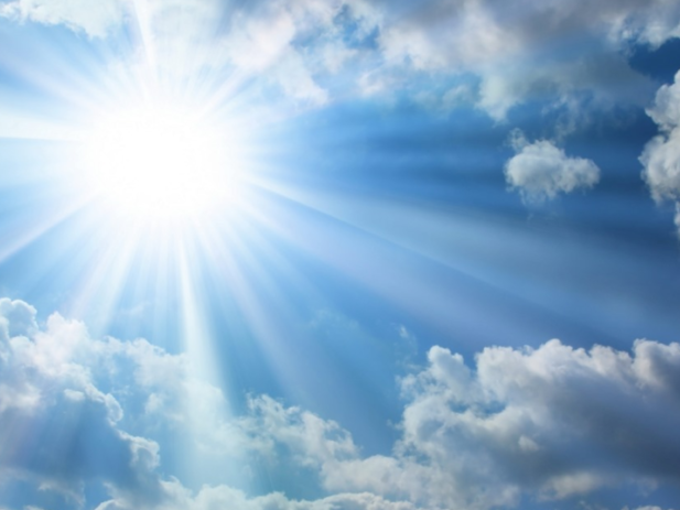Bright sunlight with blue sky and fluffy white clouds