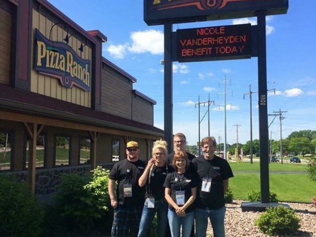 Pizza Ranch staff by their sign promoting the impact event