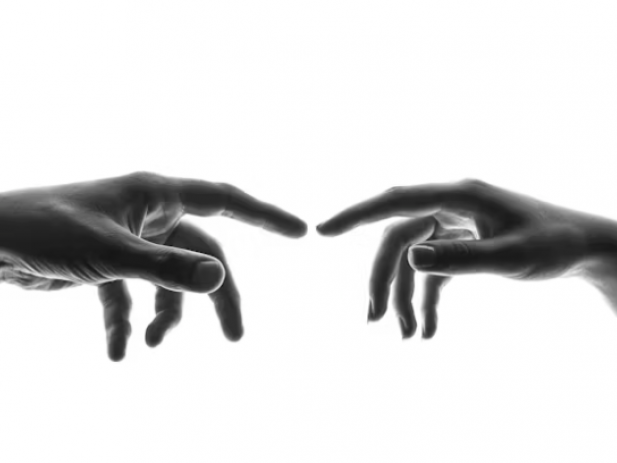 Two Hands reaching towards each other, index fingers almost touching