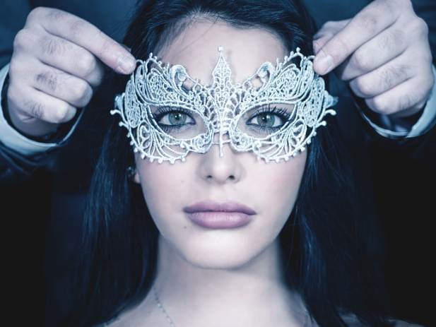 Man placing mask on lady's face