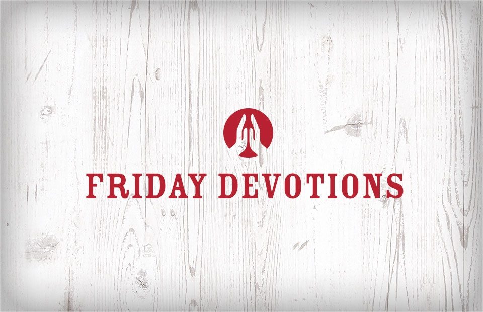 Praying hands icon above the words "Friday Devotions" in red text, on a light wooden textured background.